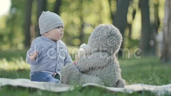可爱的小孩在公园里和玩具熊玩视频的预览图