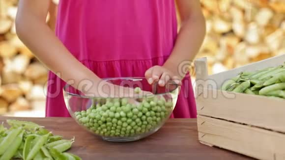 小女孩用手在玻璃碗里搅拌豌豆视频的预览图