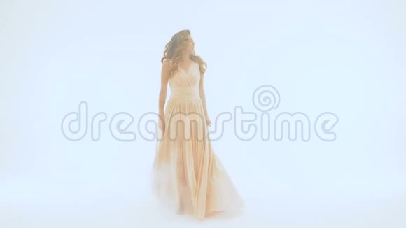 这位歌手穿着一件漂亮的长裙在白色墙壁的背景下唱歌她把手伸进去视频的预览图