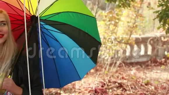 快乐的女孩带着雨伞在秋千上视频的预览图