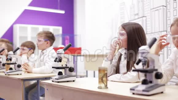 小学生物化学课孩子们透过显微镜看视频的预览图