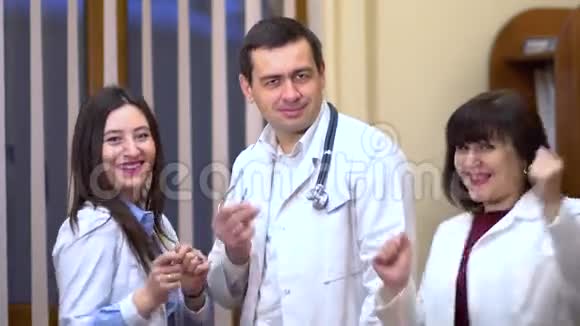 一群医生看着摄像机跳舞两个女人和一个男人视频的预览图