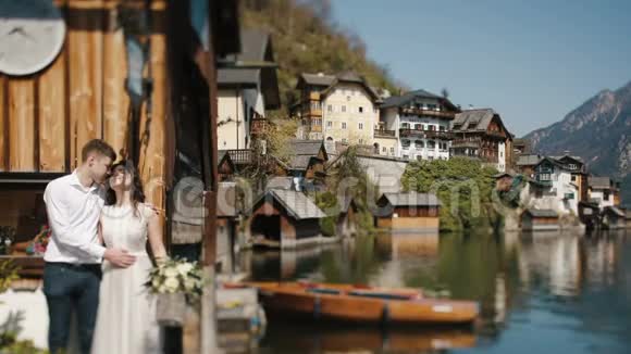 这对穿着古装的夫妇正拥抱在河边和群山的背景下周围环绕着乡村城市视频的预览图