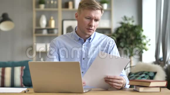 商务人士阅读文件及手提电脑文书工作视频的预览图