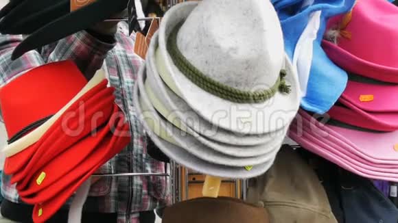 许多彩色的不同帽子挂在街道衣架上视频的预览图