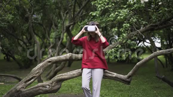 穿红衣服的女人在公园里戴着VR眼镜视频的预览图