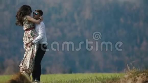 在山上穿着乡村长裙的男人抱着女孩的特写镜头视频的预览图