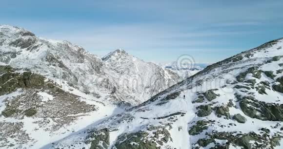 冬季前空中飞雪山口登山滑雪者向上攀爬视频的预览图