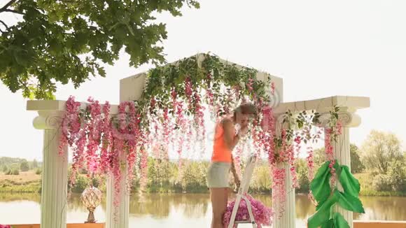女孩花店用鲜花装饰婚礼拱门视频的预览图