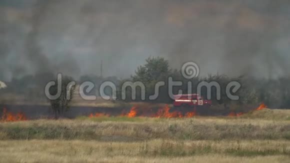 消防队员在烧焦的土地上靠近消防车准备灭火视频的预览图