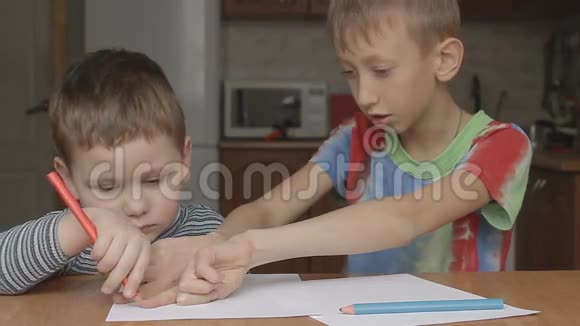 大一点的男孩展示如何画蜡笔视频的预览图