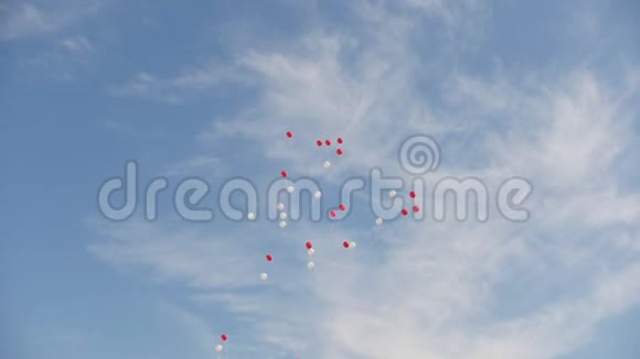 蓝色天空背景上的红白气球慢镜头视频的预览图