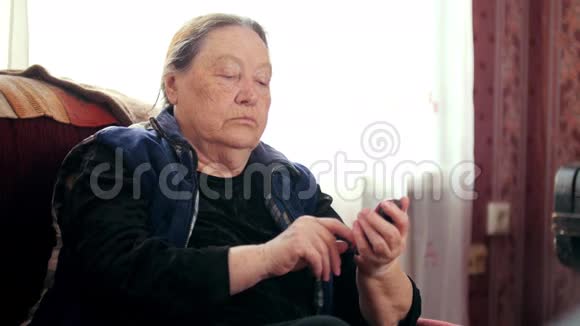 老年妇女养老金领取者讲手机电话视频的预览图