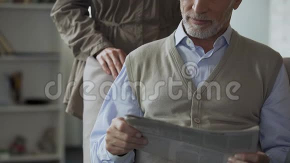 男性退休人员看报纸女性从背后拥抱充满爱意视频的预览图
