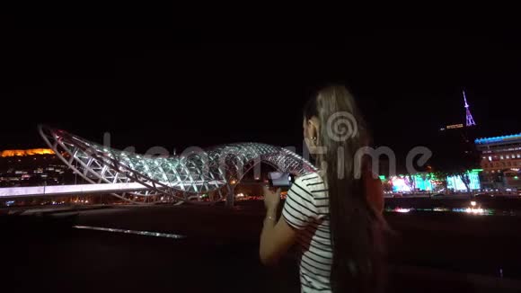 年轻女士拍摄和平之桥的照片视频的预览图