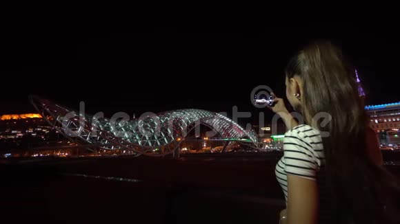 年轻女士拍摄和平之桥的照片视频的预览图
