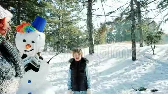 快乐的母子共度寒假一家人堆雪人雪雕装饰视频的预览图