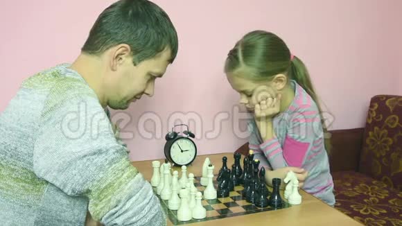 爸爸和女儿在一盘棋面前互相打招呼视频的预览图