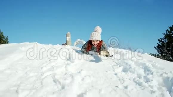 快乐的女孩骑着雪橇拍照片自拍冬天疯狂的照片女人手里拿着手机在他的手里视频的预览图