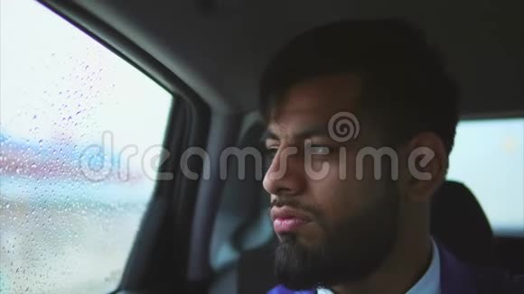 近距离观看车上年轻的穆斯林男子他坐在后座上视频的预览图