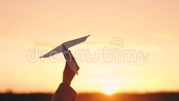 女人在日落的背景下发射纸飞机想去度假或旅行的概念慢动作视频的预览图