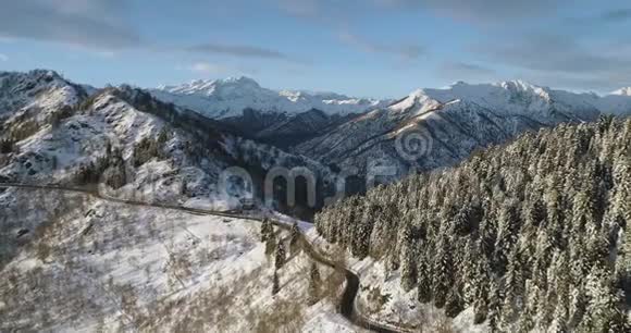 冬季白雪山关谷前方鸟瞰图森林树林雪山街道视频的预览图
