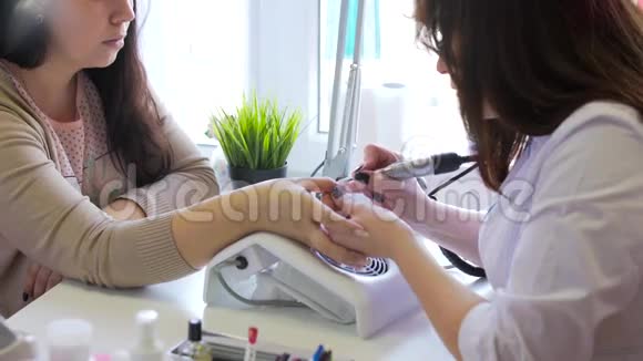 美容店的五金修甲特写镜头美甲医生正在用电指甲锉刀修指甲视频的预览图