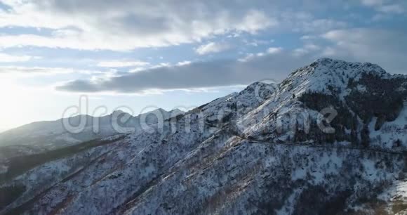 冬季白雪山侧轨空中俯视图森林树林雪山街头小路开辟者日落视频的预览图