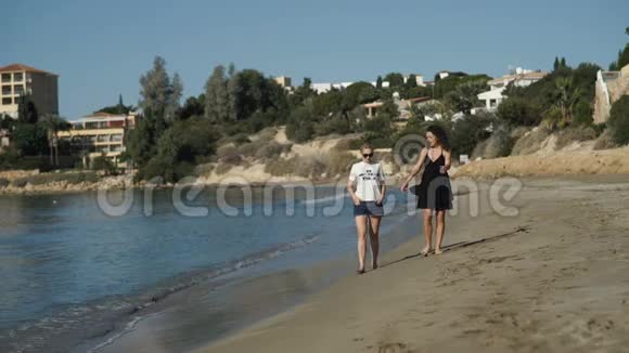 两个美丽的女孩正沿着海边散步视频的预览图