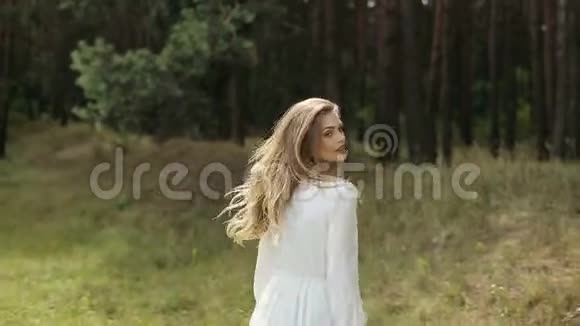 穿着白色衣服的女孩赤着脚走在炎热的夏日草地上视频的预览图