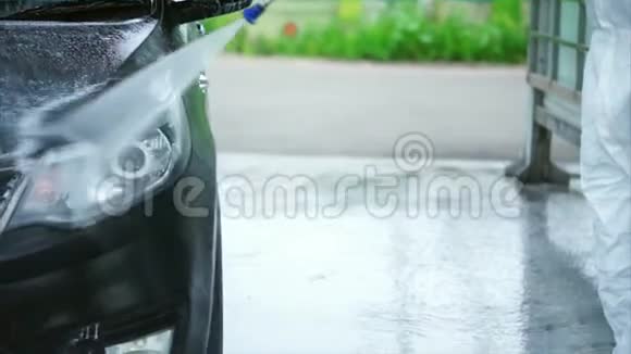 年轻人把泡沫从车上洗下来洗车自助服务视频的预览图