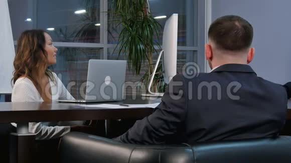 一群成功的商人在办公室会议室里围着桌子说话视频的预览图