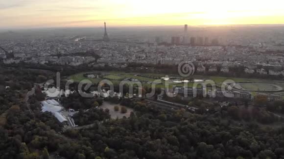 在清晨升起的太阳下用埃菲尔铁塔从布洛涅森林俯瞰巴黎天际线视频的预览图