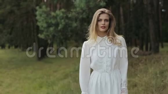 穿着白色衣服的女孩赤着脚走在炎热的夏日草地上视频的预览图