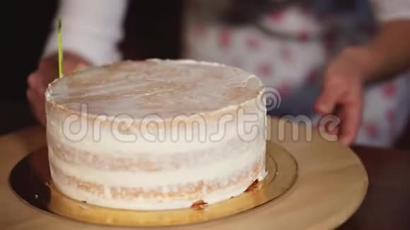 厨娘用鲜奶油装饰烤制的分层蛋糕视频的预览图