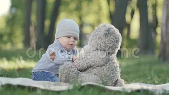 小男孩在公园的封面上玩玩具熊视频的预览图
