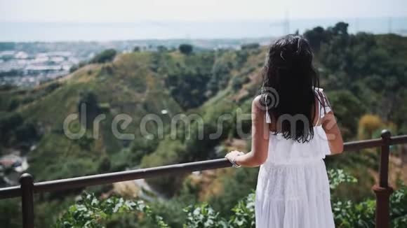 站在别墅露台上看城市的白衣少女视频的预览图