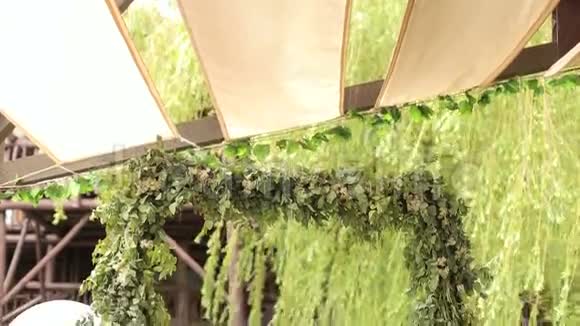 咖啡馆里绿色树枝的婚礼拱门视频的预览图