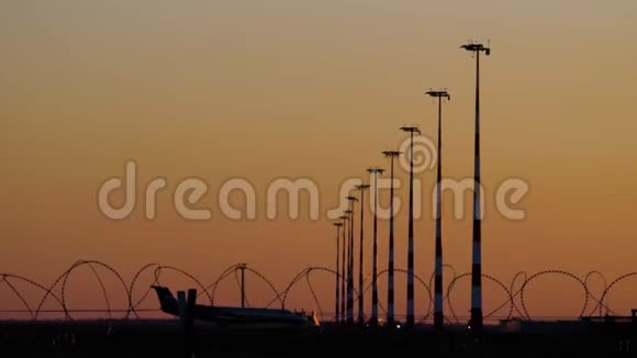 日落阳光机场的飞机轮廓飞机栅栏轮廓后面的跑道飞机飞机视频的预览图