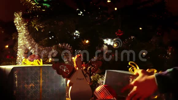 为圣诞节做准备孩子们手把礼物放在圣诞树下视频的预览图