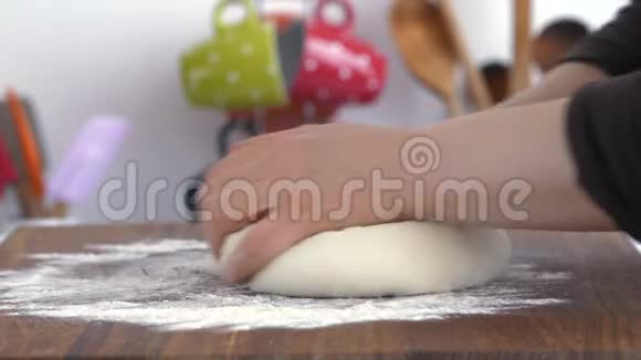 面包师在桌子上用面粉揉面团视频的预览图