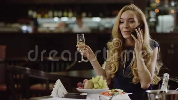 女商人通过电话交谈在餐馆喝酒视频的预览图