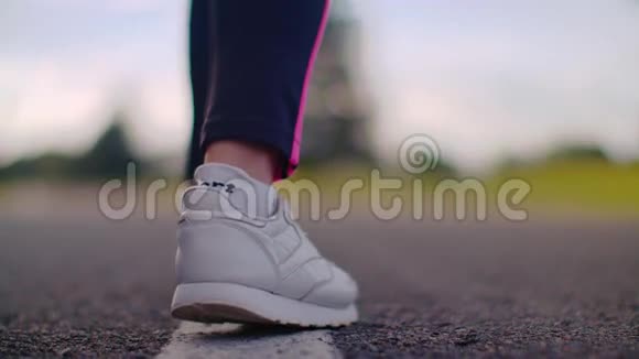 女选手开始跑在公路上穿白色运动鞋的跑步者腿视频的预览图