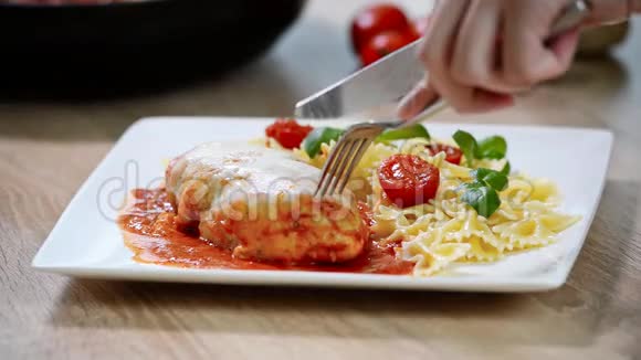 意大利菜鸡肉配番茄和面食特写女孩吃东西视频的预览图