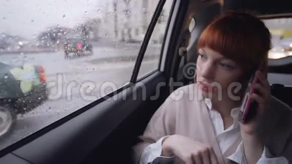 汽车里的女人在谈论粉红色的手机视频的预览图