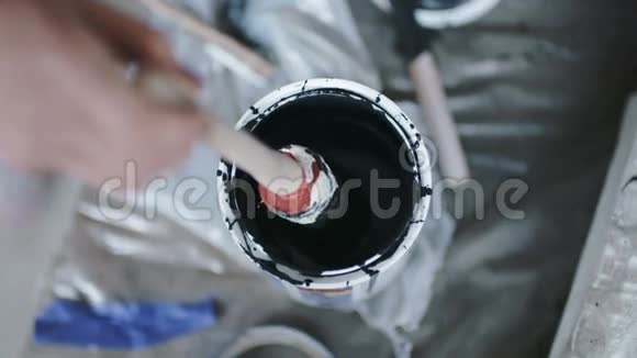 个人在黑色油漆罐中浸粘视频的预览图