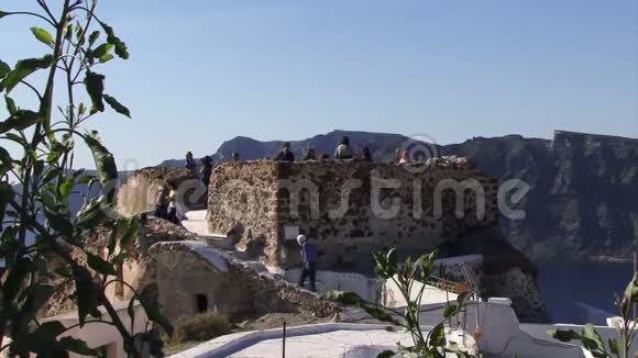 希腊圣托里尼岛的人们在远处攀爬塔视频的预览图
