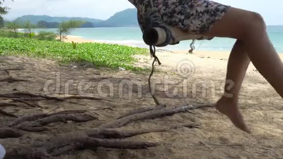 泰国普吉岛夏季的一天一位女士在带着蓝天背景的热带海滩上荡秋千放松身心尽情享受视频的预览图