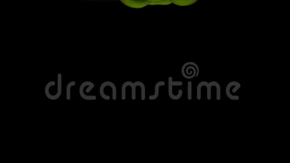 一个绿色的狗仔落在透明的水中黑色的背景视频的预览图