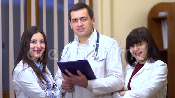 一群医生看着摄像机微笑着男医生留片视频的预览图